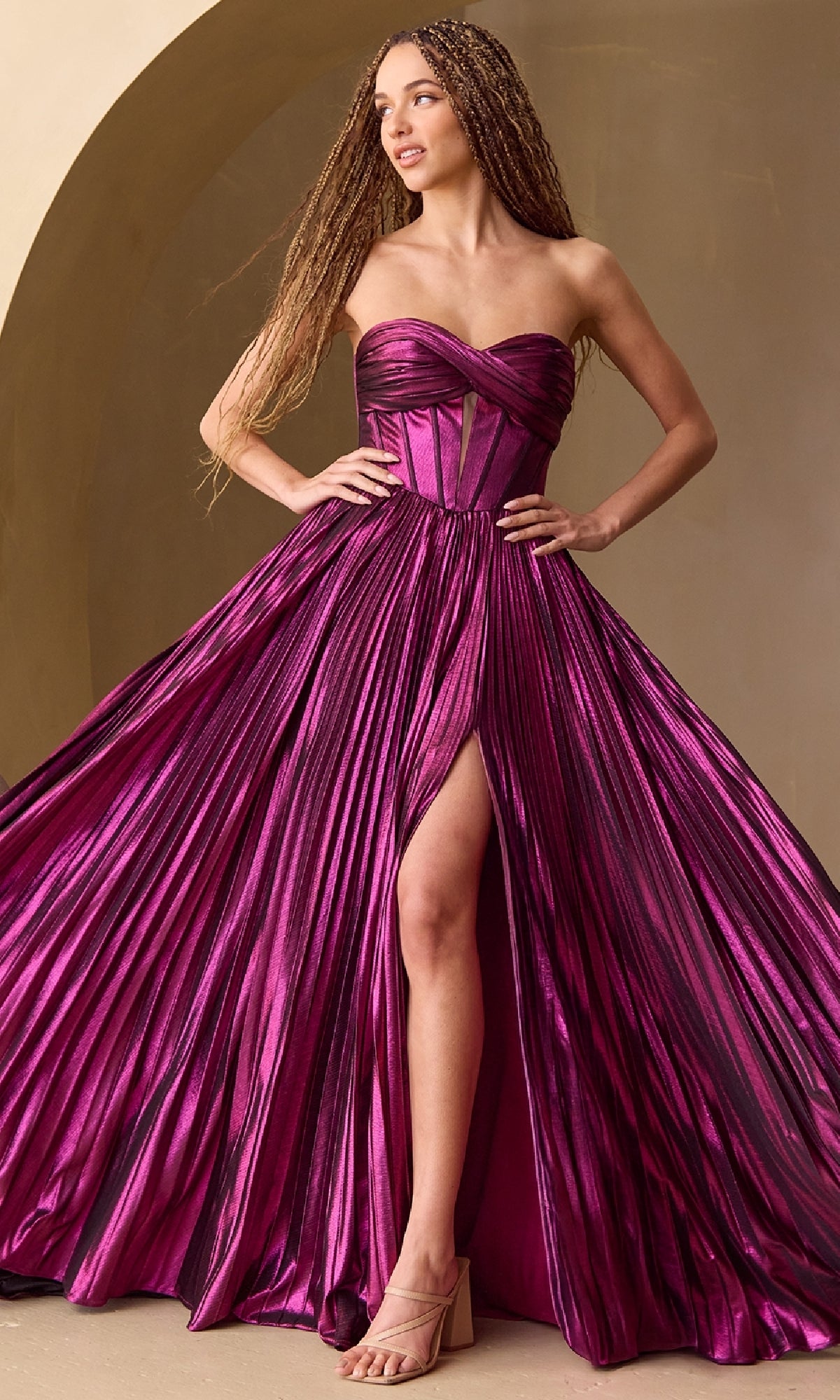 Woman wearing a strapless, floor-length purple gown with a slit on a beige background